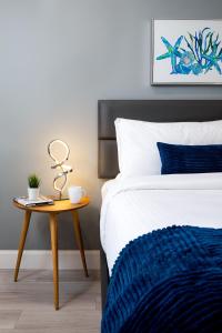 劳德代尔堡The Lauderdale Boutique Hotel的一间卧室配有一张床和一个带蓝毯的床头柜。