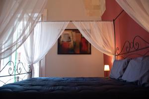 塔兰托Arabesque Luxury Apartment - Roof Garden的一间卧室配有一张带天蓬和窗户的床