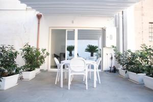 塔兰托Arabesque Luxury Apartment - Roof Garden的庭院里种有盆栽植物,配有白色的桌椅