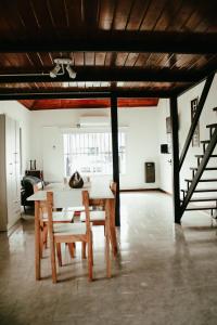 蒂格雷Casa Tipo Loft- Tigre Centro的一间带桌椅和楼梯的用餐室