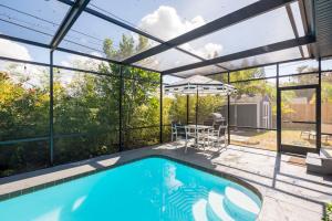 克利尔沃特Beautiful Clearwater home!的一座带大玻璃延伸的房屋内的游泳池