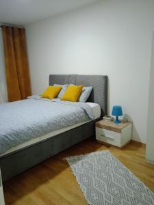 萨拉热窝Apartman Zana的一间卧室配有一张带黄色枕头和地毯的床