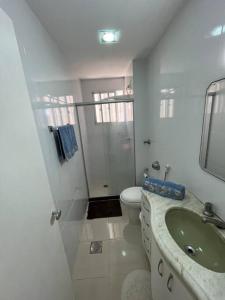 维多利亚Aloha aluguel para temporadas的白色的浴室设有水槽和卫生间。