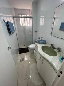 维多利亚Aloha aluguel para temporadas的白色的浴室设有水槽和卫生间。