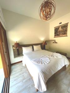 因巴塞The Madalena Pousada的卧室配有一张带吊灯的大型白色床。