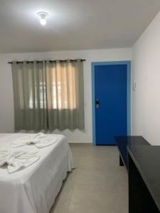 阿布拉奥Suite Grega 5- Centro da Vila Abrãao的一间卧室配有一张床和一个蓝色的门