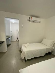 阿布拉奥Suite Grega 5- Centro da Vila Abrãao的白色的房间,设有床和走廊