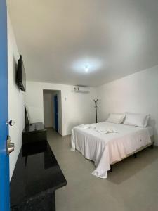 阿布拉奥Suite Grega 5- Centro da Vila Abrãao的白色卧室配有床和书桌