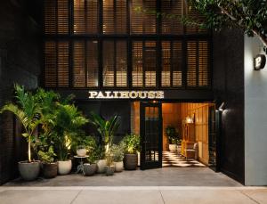 坦帕Palihouse Hyde Park Village的一座种植了盆栽植物的宫殿建筑的入口