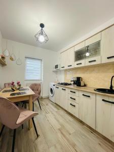 瓦特拉多尔内Apartament CHIC的厨房配有白色橱柜和桌椅