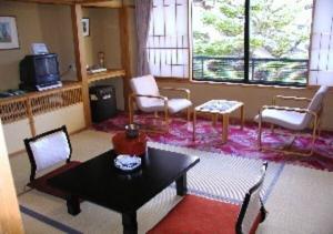 酒田市Wakaba Ryokan / Vacation STAY 29370的客厅配有桌椅和电视。