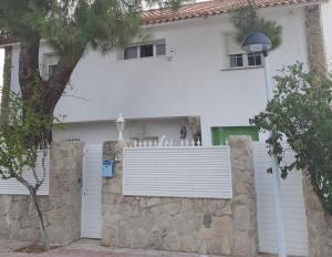 莫斯托雷斯Casa Pinares的白色的房子,有门和栅栏
