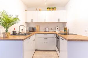 勒沃库森Apartment Leverkusen的白色的厨房配有木制台面和白色橱柜
