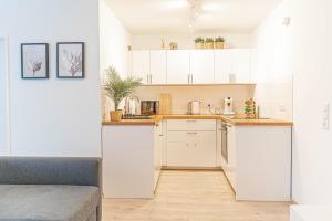 勒沃库森Apartment Leverkusen的一间厨房,内设白色橱柜和沙发