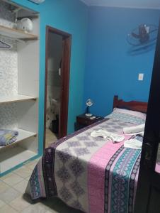 萨夸雷马CASA DA BARRA- Suítes privativas em Saquarema的一间卧室设有一张床和蓝色的墙壁