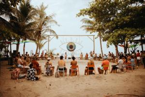 伯里塔卡Viajero Tayrona Hostel & Ecohabs的一群人坐在沙滩上的椅子上