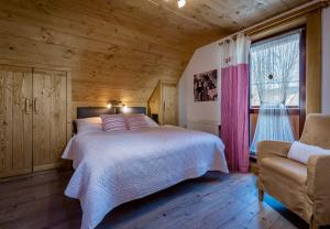 斯祖贝莱克Chata Škerda - Zuberec的卧室配有床、椅子和窗户。