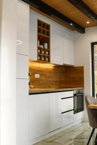 亚霍里纳The View Luxury Chalet的厨房配有白色橱柜和木制台面