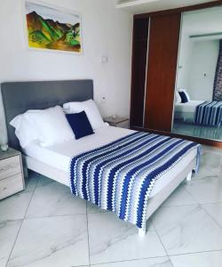 塔拉法尔Residencial Santo Amaro的一间卧室配有一张带蓝白条纹毯子的床