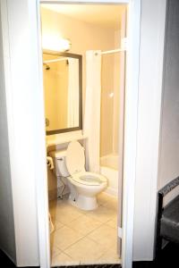 亚克朗Copley Inn & Suites, Copley - Akron的浴室配有卫生间、盥洗盆和浴缸。