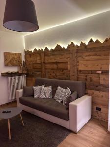 卡瓦莱塞Appartamento "Roby" in pieno centro a Cavalese的带沙发和木墙的客厅