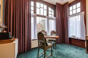 斯滕韦克Villa Steenwyck Giethoorn的客房设有桌椅和窗户。