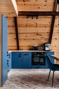 里梅泰亚KARL's Cabin by Black & White Panoramic的厨房配有蓝色橱柜和木墙