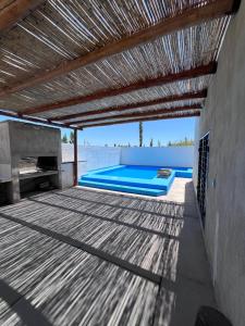 阿尔韦亚尔将军镇Casa con pileta privada的户外甲板设有游泳池和木制天花板