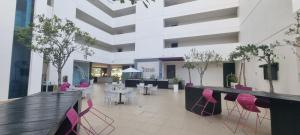 里奥阿托Amplio y Bello Estudio en Town Center Playa Blanca, Rio Hato的大堂,大楼内摆放着粉红色的椅子和桌子