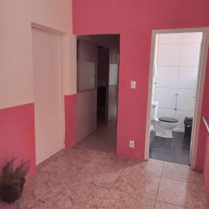 佩洛塔斯Pousada VIDA的一间设有红色墙壁的客房和一间带卫生间的浴室