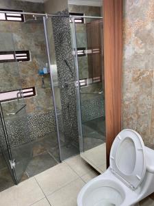 昆卡Evangelio Inn的一间带卫生间和玻璃淋浴间的浴室