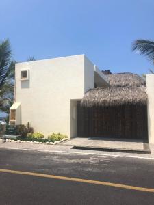锡瓦塔塔内霍New Beachfront Villa in Playa Blanca的街道一侧有茅草屋顶的建筑