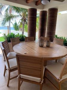 锡瓦塔塔内霍New Beachfront Villa in Playa Blanca的棕榈树庭院里的一张木桌和椅子