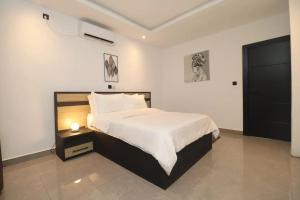 杜阿拉VOAK Home的一间卧室配有一张大床和一个床头柜