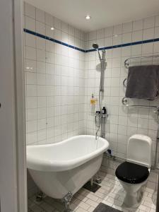 斯德哥尔摩Apartment in the middle of So-Fo, Södermalm, 67sqm的白色的浴室设有浴缸和卫生间。