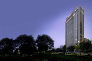 西安Hilton Xi'an High-tech Zone的前面有树木的高楼