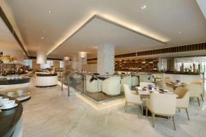西安Hilton Xi'an High-tech Zone的餐厅设有酒吧和桌椅