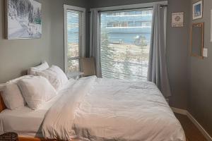 大白山The Lepard's Den - Whitefoot Lodge 206的卧室配有一张大白色床和窗户
