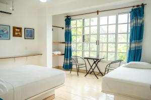 马祖特Casa Mazunte Tierra Viva的一间卧室设有两张床、一张桌子和一个窗口