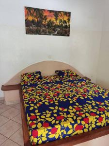 AbéméCampement Nyabinghi的卧室内一张带五颜六色棉被的床