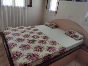 AbéméCampement Nyabinghi的一张带花卉棉被的床和两个枕头
