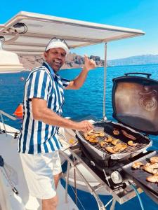 希克杜沃RM Holiday Home的船上的烤架上的人做饭