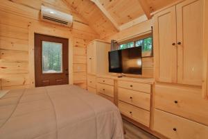 查塔努加Stefan Cabin Nature-nested Tiny Home Hot Tub的一间卧室配有一张床和一台平面电视