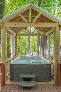 查塔努加Stefan Cabin Nature-nested Tiny Home Hot Tub的一个带木制屋顶的凉亭里的大型热水浴池