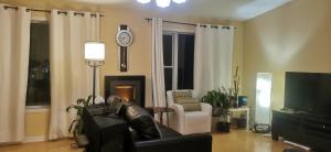 伊魁特Grant Arctic Escape的客厅配有沙发和墙上的时钟