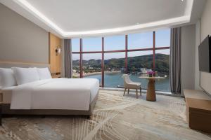 舟山舟山海景皇冠假日酒店的酒店客房设有一张床和一个大窗户