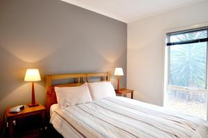 因沃洛什Flying Colours的一间卧室配有一张带两盏灯的床和一扇窗户。