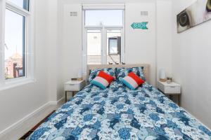 悉尼2BR Bondi Beauty - Elena by the Sea的一间卧室配有蓝色和红色枕头的床