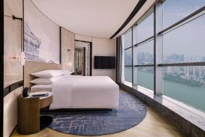 武汉武汉襄投万豪酒店的一间卧室设有一张床和一个大窗户