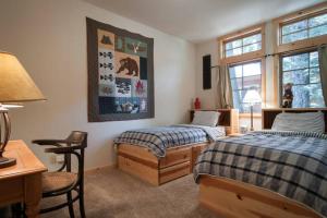 奥林匹克谷Sierra Crest at Palisades Tahoe - Secluded Luxury 5BR 5 BA w Wood Fireplace的一间卧室配有两张床、一张桌子和一张书桌